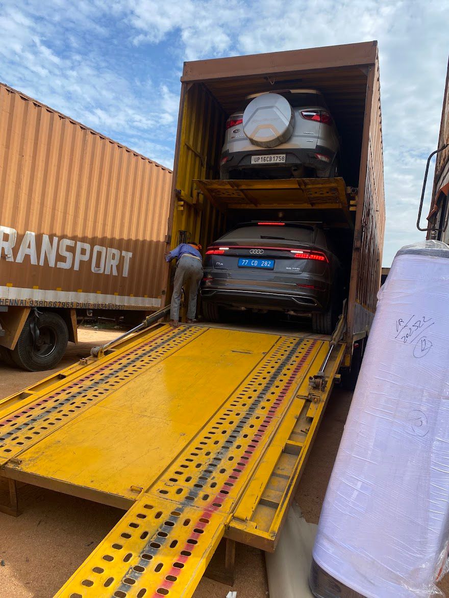 Car transport service — SUV and Audi loaded inside enclosed car carrier truck