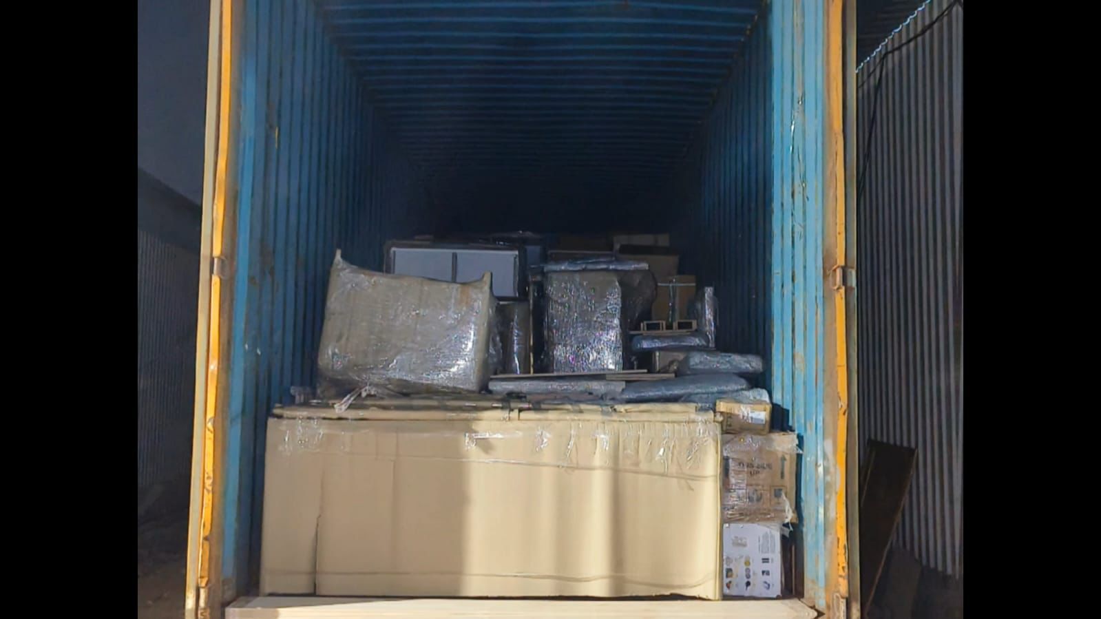 Container view — household items packed and stacked for transport