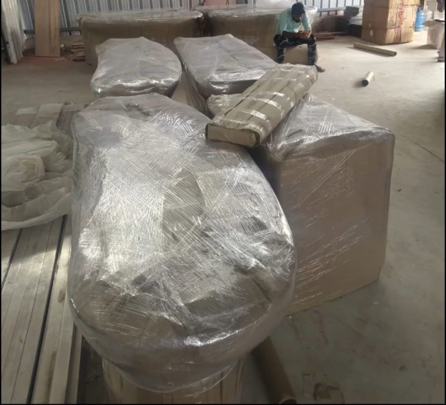 Sofas and large furniture wrapped in stretch film at packing facility