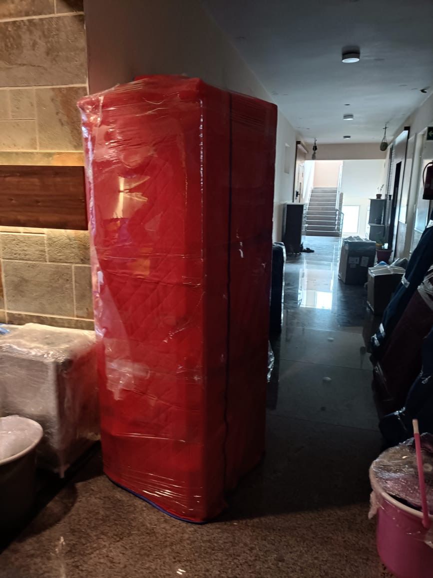 Tall wardrobe wrapped with quilt and stretch film for safe shifting